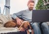 man working on laptop with dog